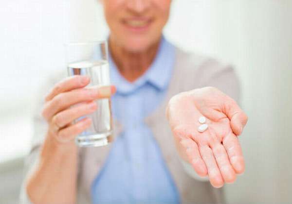 лекарство и стакан воды в руках