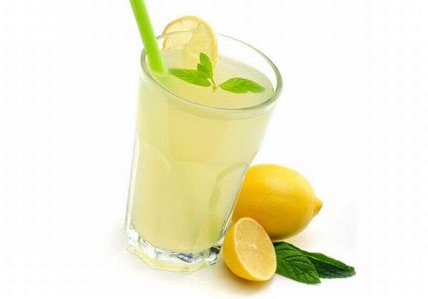 Стакан с лимонным соком и лимоны